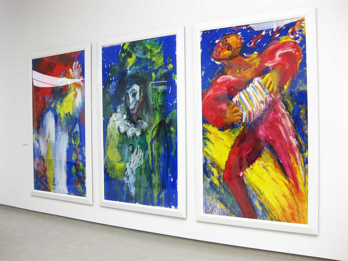 Drei große, nebeneinander hängende Bilder mit kräftigen Blau-/ Gelb- und Rottönen im Kunstmuseum Manfred Luz