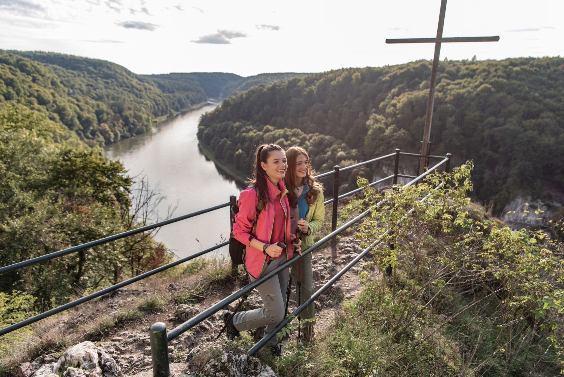Das Wieserkreuz ist ein Aussichtspunkt im Naturschutzgebiet Weltenburger Enge. Zwei Wanderer genießen hier den Ausblick über die Donau und die umliegenden Wälder.
