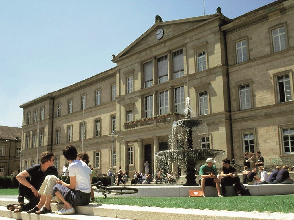 Studenten sitzen vor den Brunnen auf dem Vorplatz der Neuen Aula der Universität Tübingen