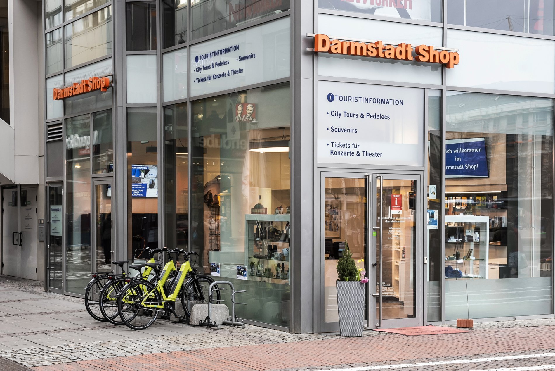 Darmstadt Shop mit großen Schaufenstern, davor vier Elektrofahrräder, im Ladeninneren verschiedene Vitrinen und Prospektständer.