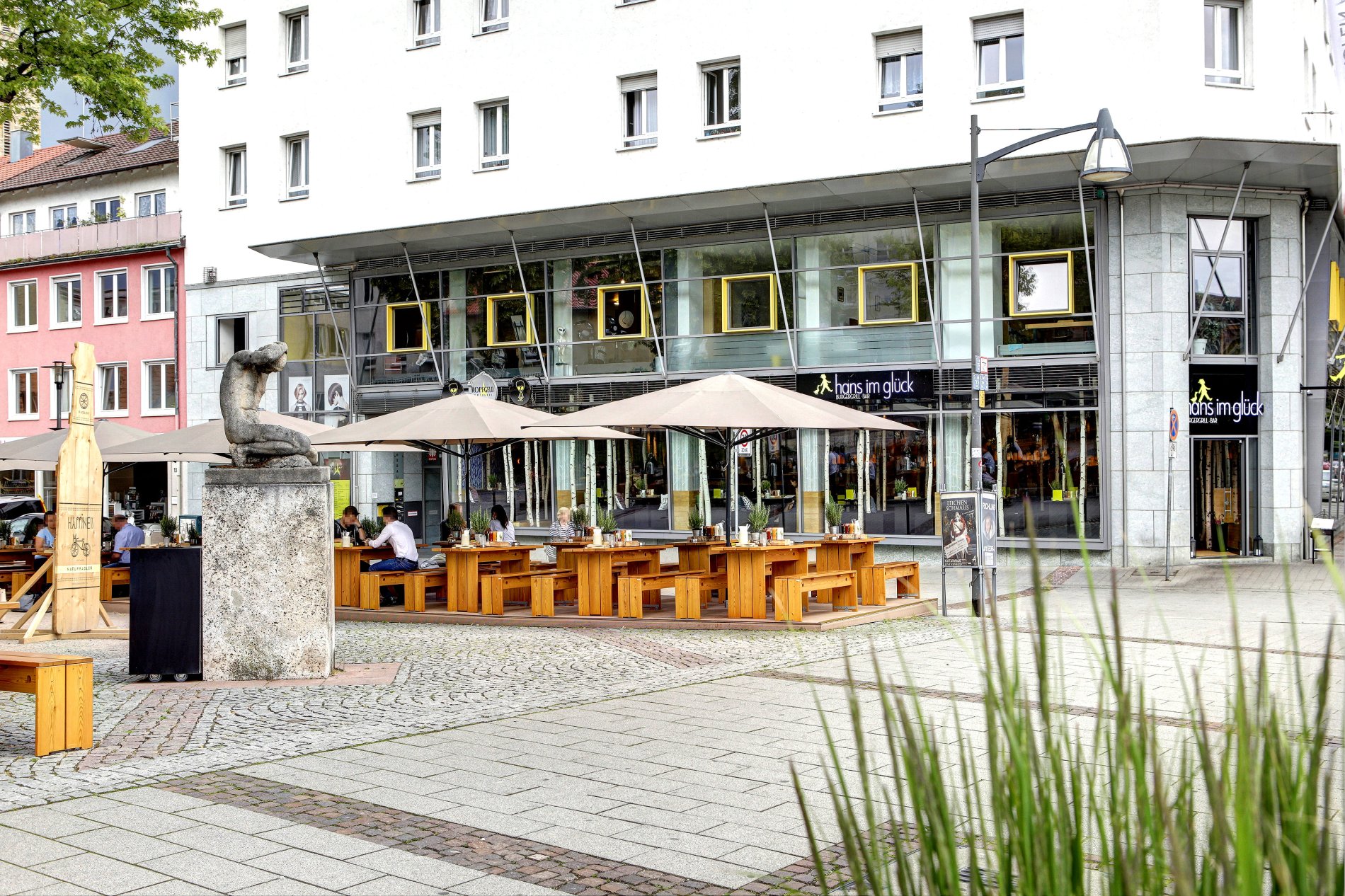 Vue extérieure de Hans im Glück avec terrasse et places assises abritées