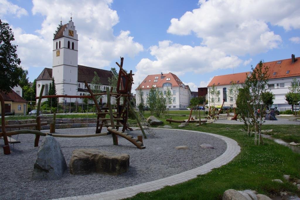 Spielplatz mit Kirche und Rathaus im Hintergrund