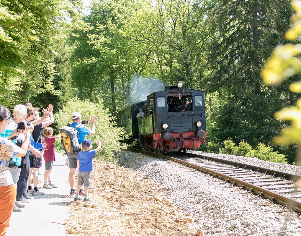 Eisenbahnschiene mit einem alten Zug und Gästen