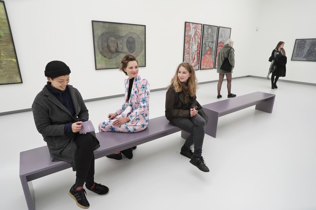 Junge Menschen sitzen auf einer Besucherbank in einem Ausstellungsraum der Kunsthalle Tübingen