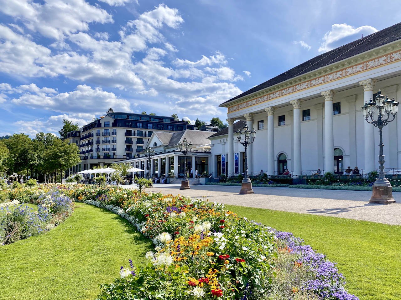 Kurhaus behind a richly planted flower bed with blue sky