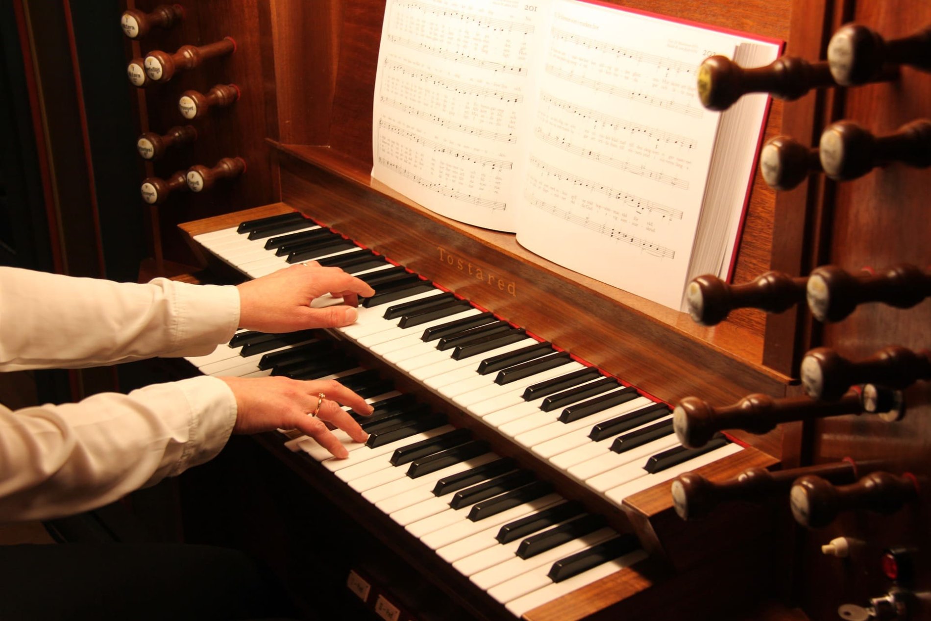 Eine Organistin spielt die Orgel.