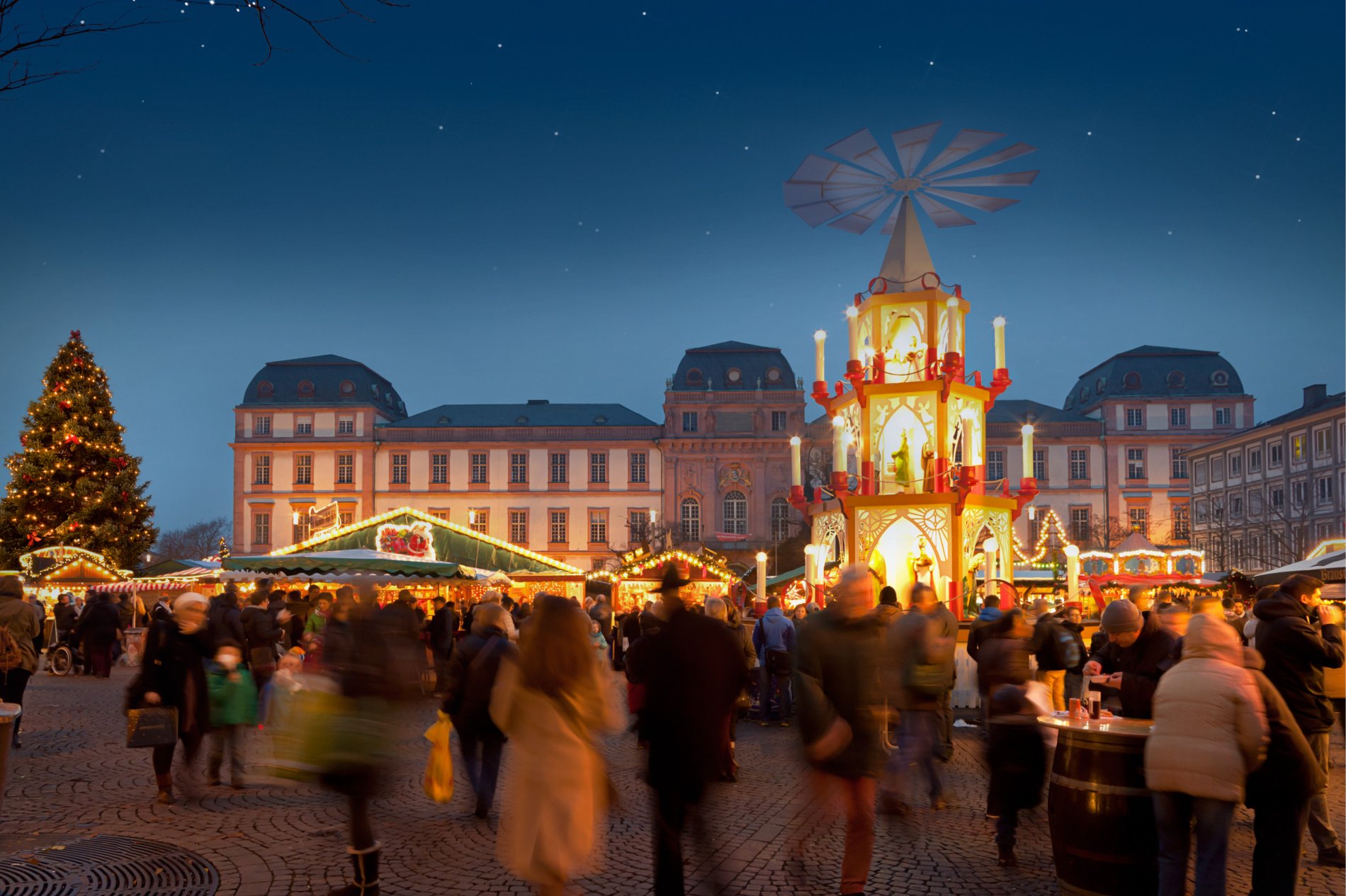 Blick von oben auf den Marktplatz mit beleuchtetem Weihnachtsbaum und Weihnachtsmarktständen, im Hintergrund das Alte Rathaus und der Turm der Stadtkirche.