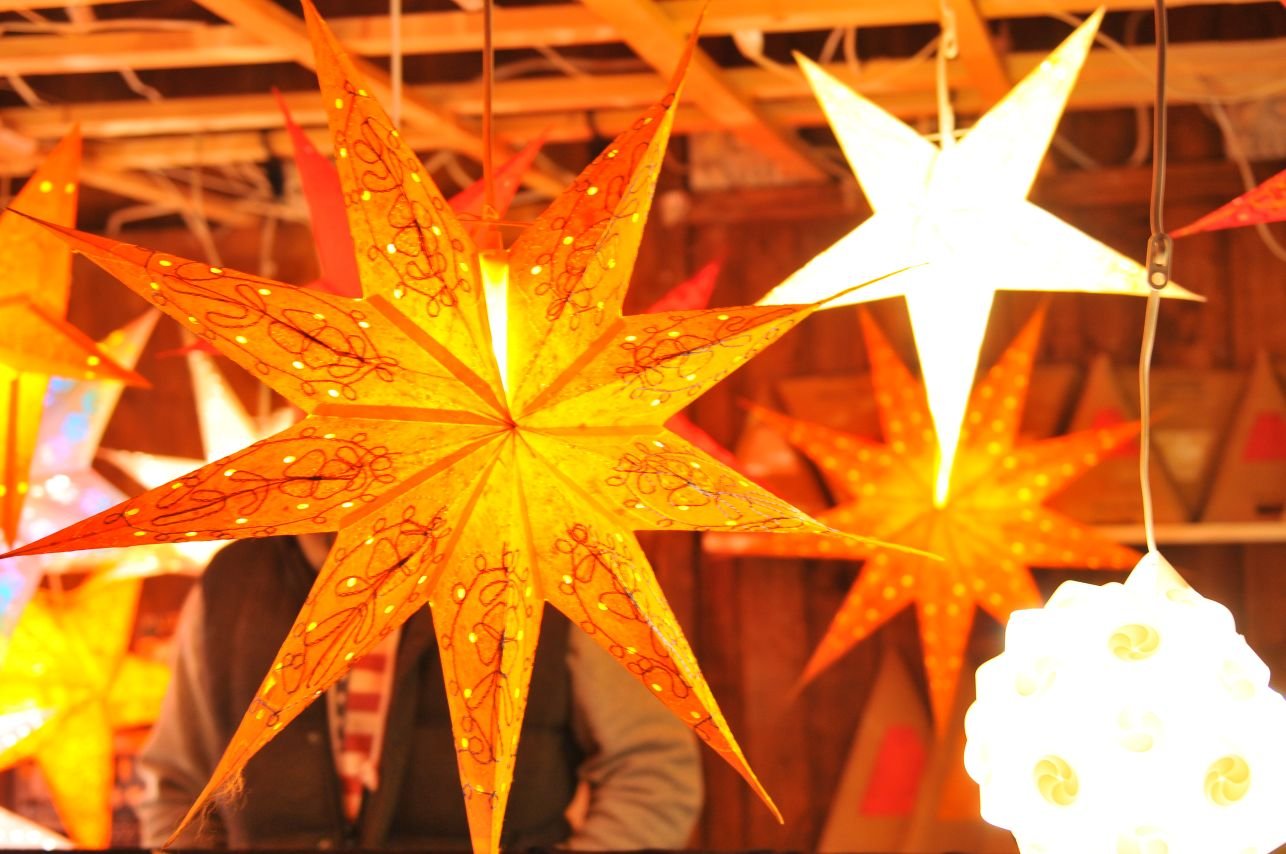 Der Weihnachtsmarkt in Münsingen im Biosphärengebiet Schwäbische Alb. Von der Decke hängen mehrere beleuchtete Papiersterne.