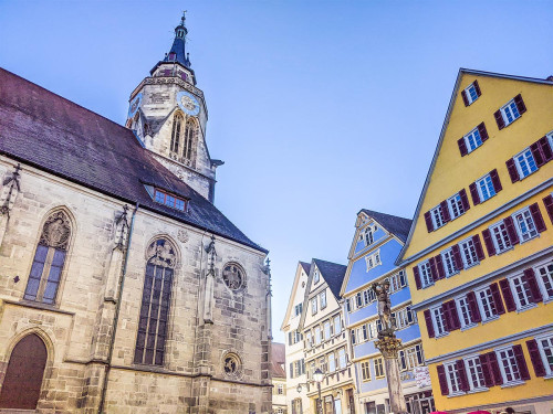 Church of St. George Tübingen with half-timbered houses against a blue sky
