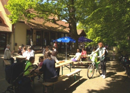 Die Besucher des Cafés im Jugendhof genießen im Schatten Kaffee und Kuchen.