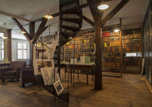 Innenansicht vom Hesse-Kabinett Tübingen mit Holzsäulen und großen Bücherregalen