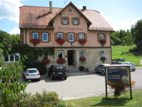Ein historisches Haus mit orangener Fassade und der Aufschrift Gestütsgasthof.